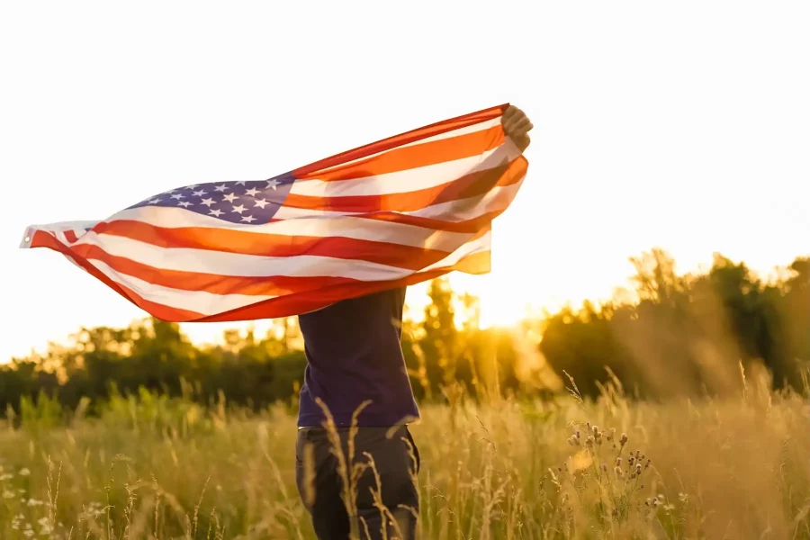 Inmigrante en Estados Unidos sosteniendo bandera